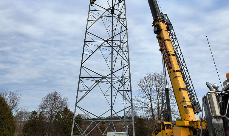 Yellow crane beside metal tower